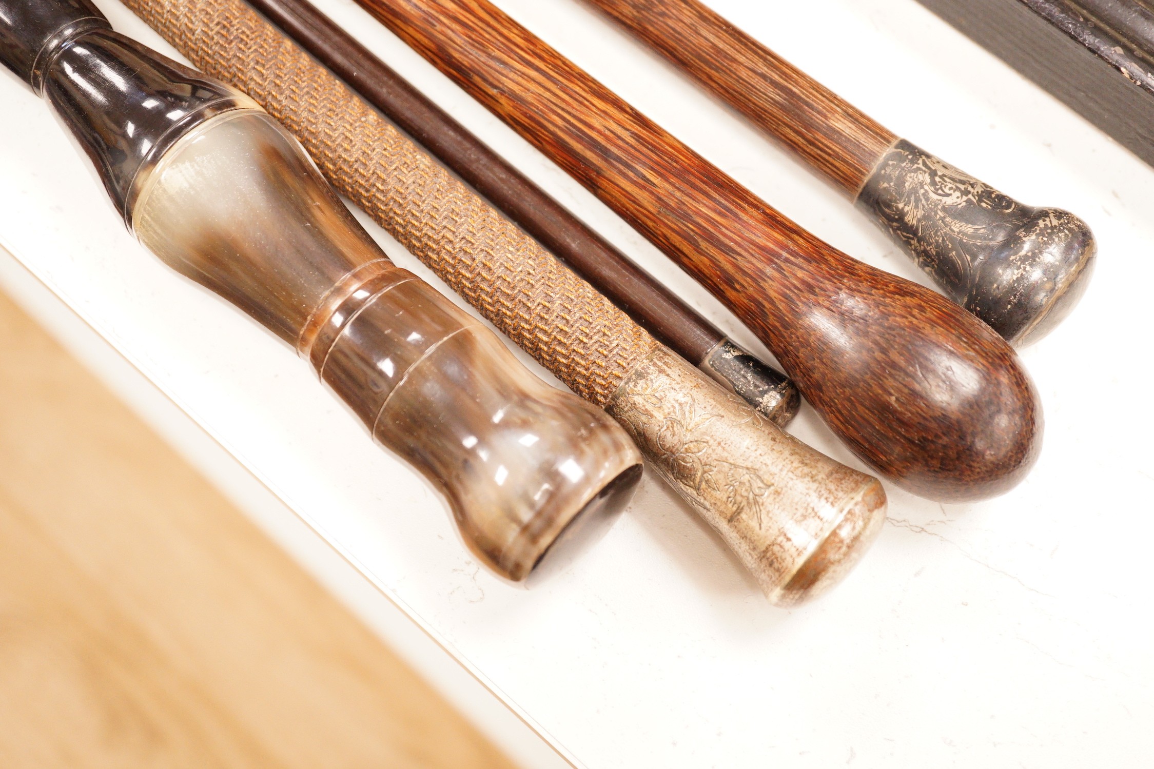 Five assorted walking canes / to include an amboyna example, a sectional horn example, two silver topped etc.